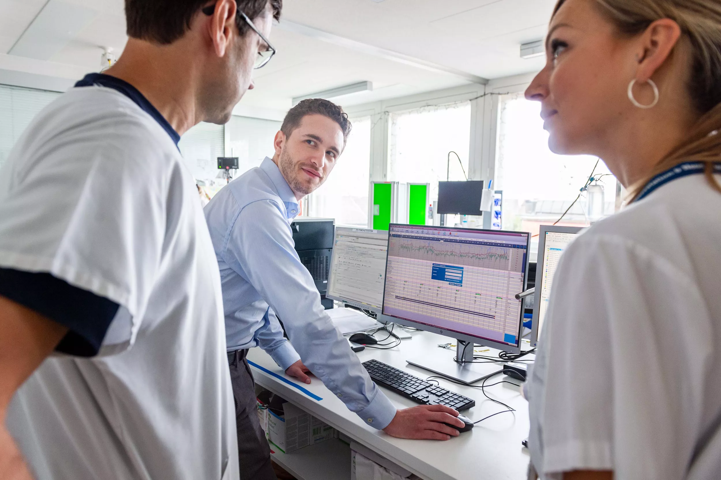 Informatiker spricht mit Arzt und Pflegefachfrau