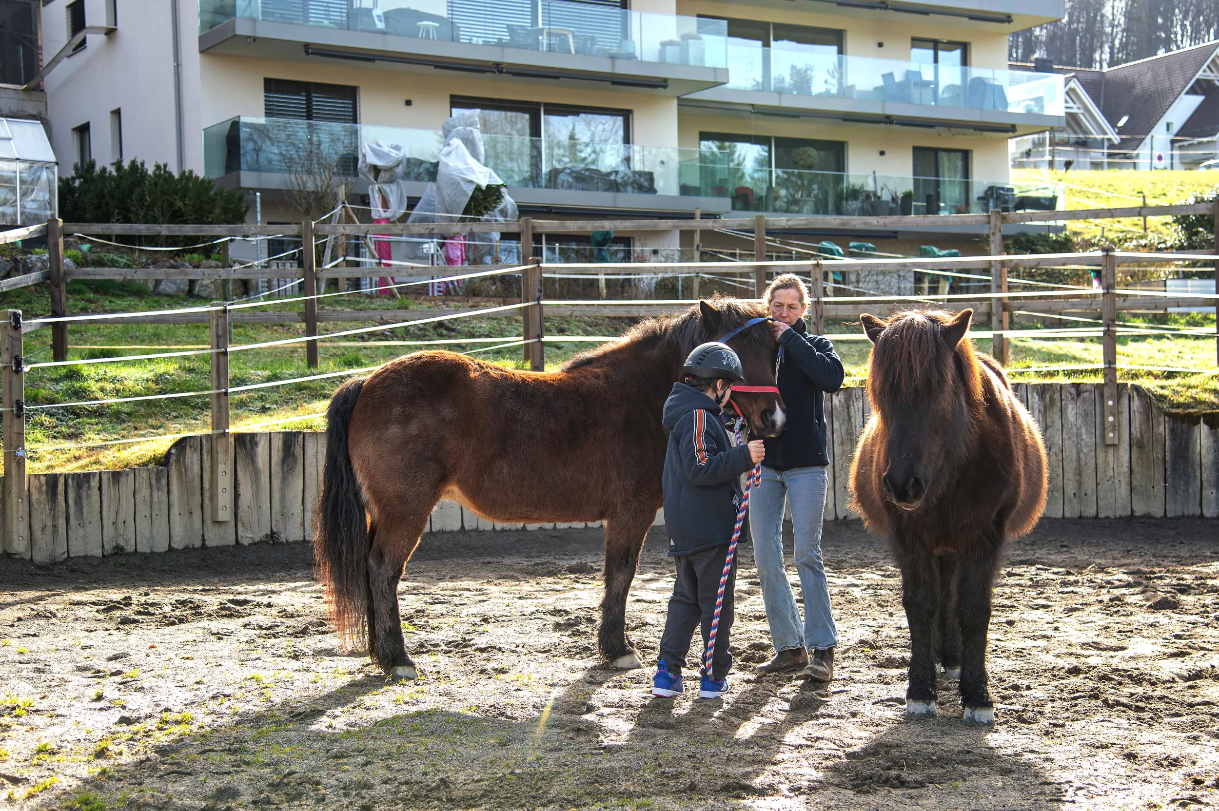 Eine Therapeutin und ein Kind bei der pferdegestützten Therapie