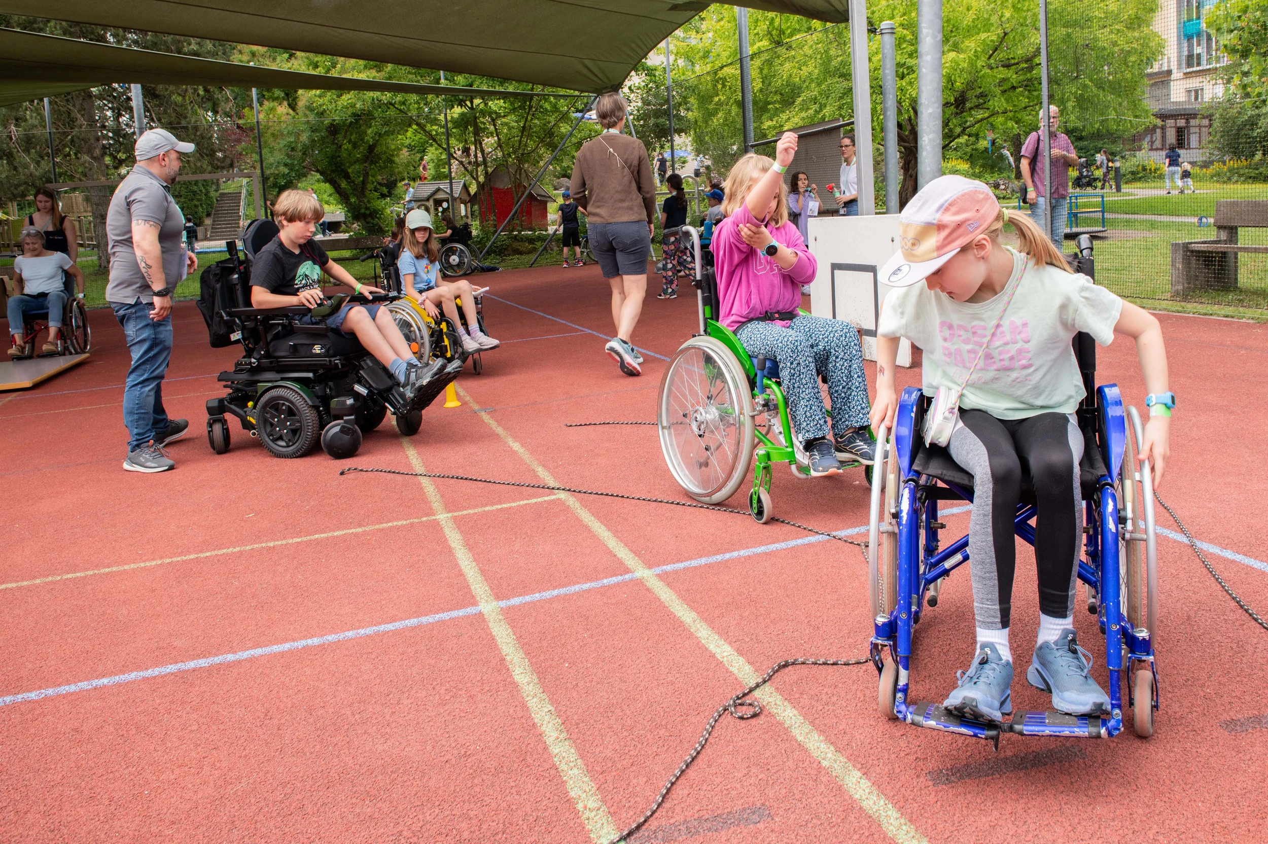 Kinder und Erwachsene beim Rollstuhl-Parcours am Tag der offenen Tür in der Kinder-Reha Schweiz