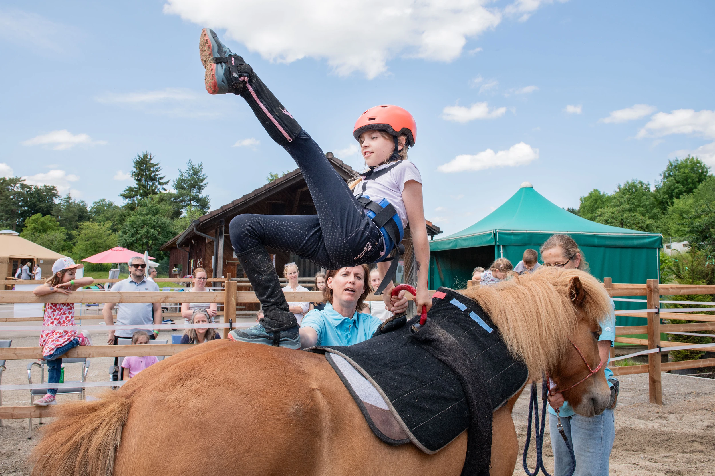 Ein Kind macht auf einem Therapiepferd in der Kinder-Reha Schweiz akrobatische Übungen