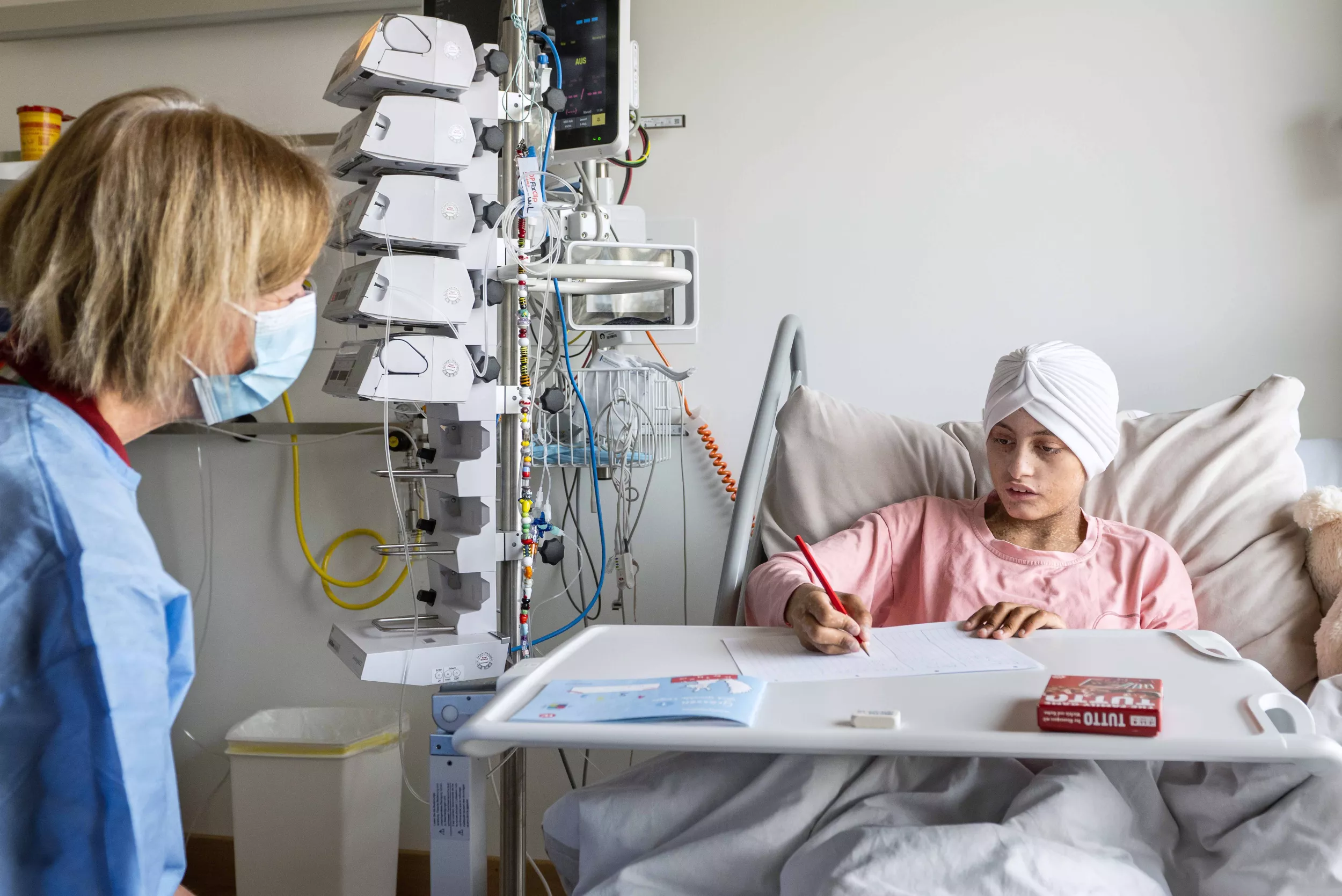 Lehrperson mit Patientin in einem Patientenzimmer des Kinderspitals Zürich