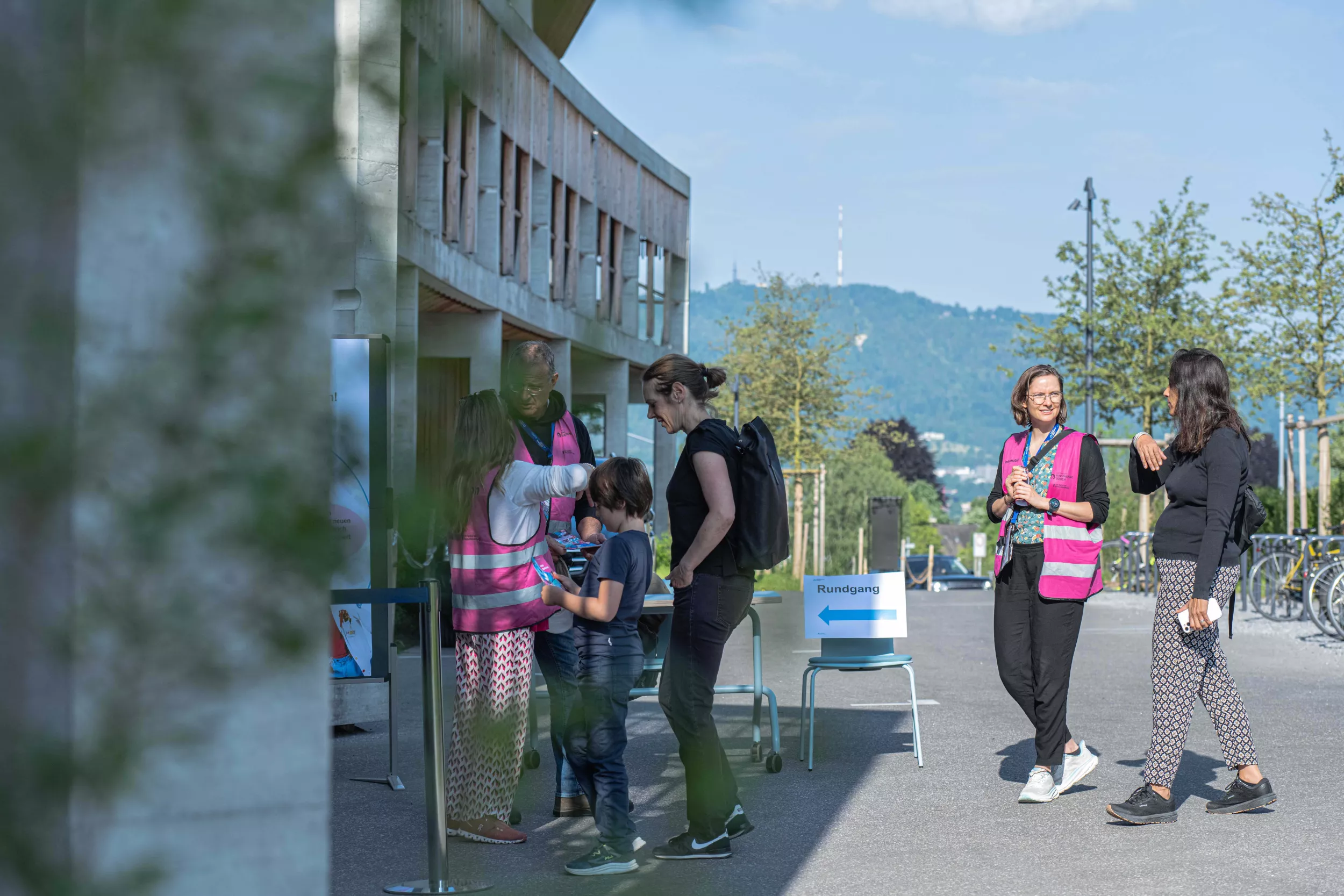 Freiwillige informieren Besuchende beim Haupteingang