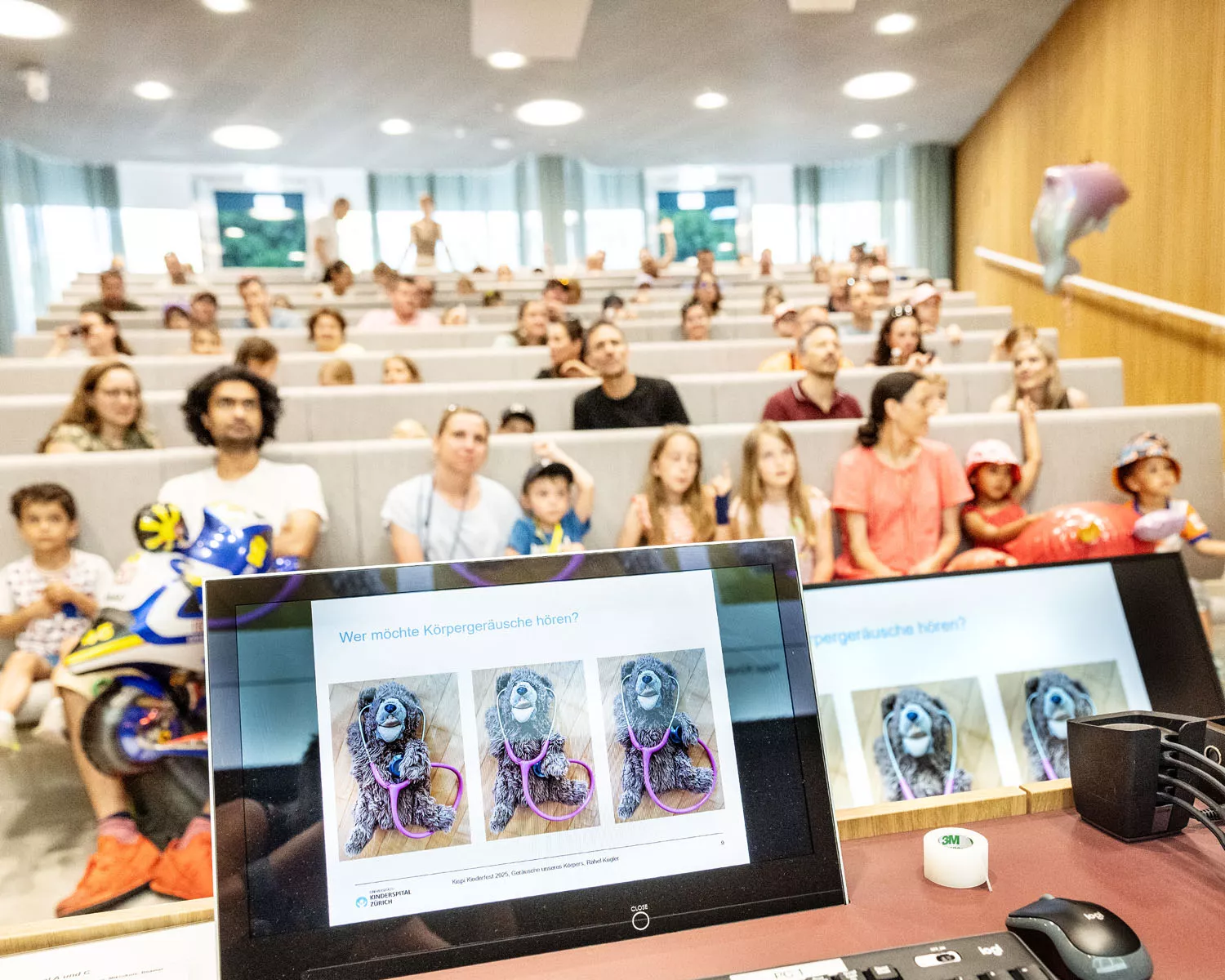 Besuchende lauschen im Hörsaal einem Vortrag