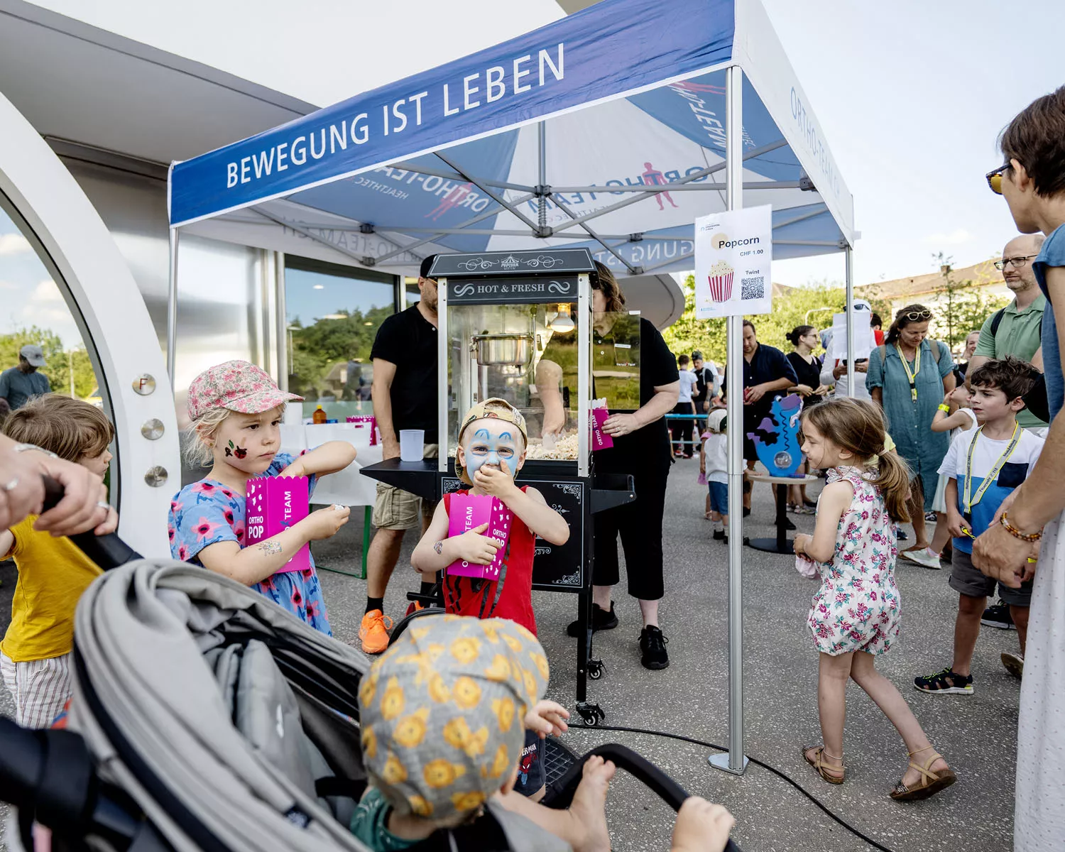 Kinder essen Popcorn am Kispi-Kinderfest