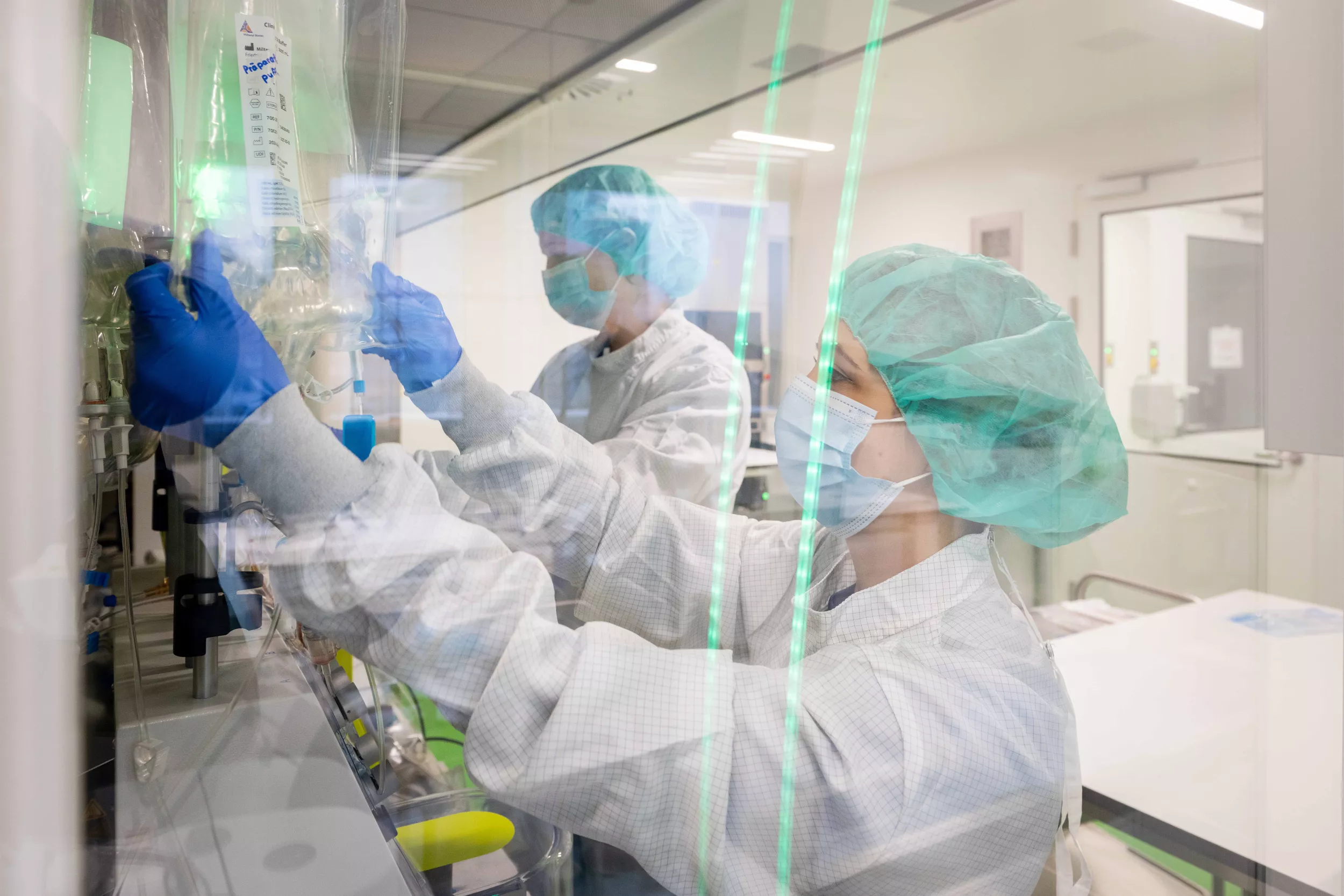 Zwei Biomedizinische Analytikerinnen untersuchen Zellprodukte in einem GMP-Labor