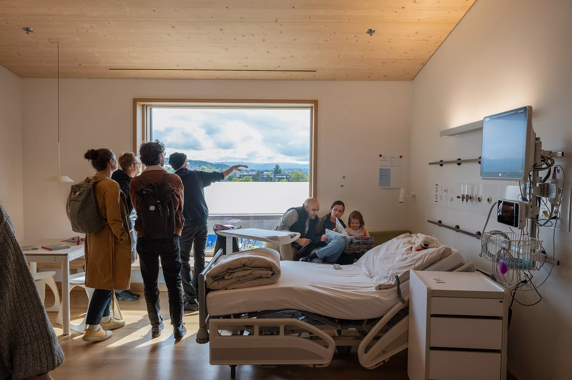 Erwachsene und Kinder besichtigen ein Patientenzimmer im Akutspital des Kinderspitals Zürich