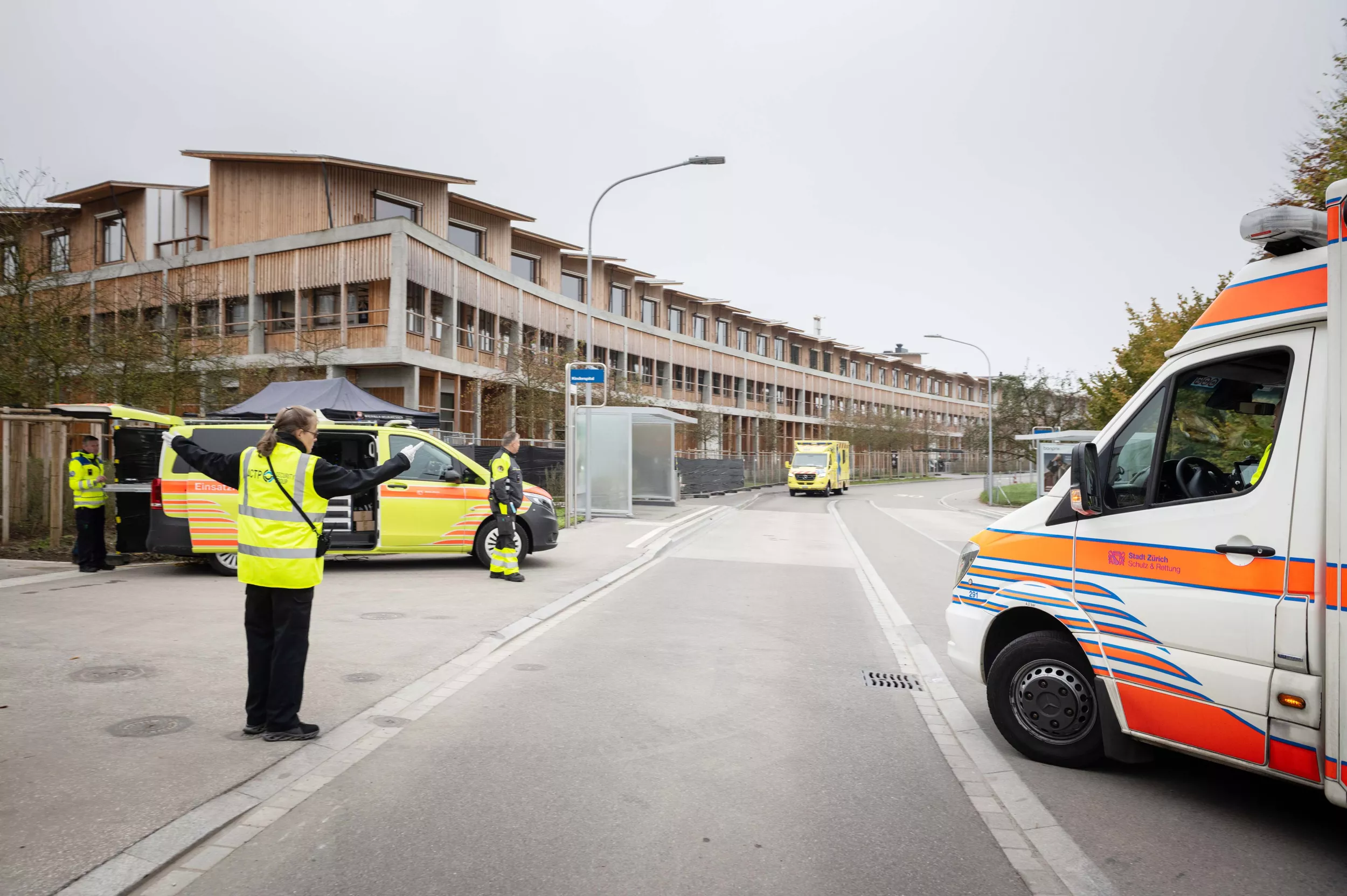 Eine Frau in Warnweste lotst einen Rettungswagen zum Kinderspital Zürich