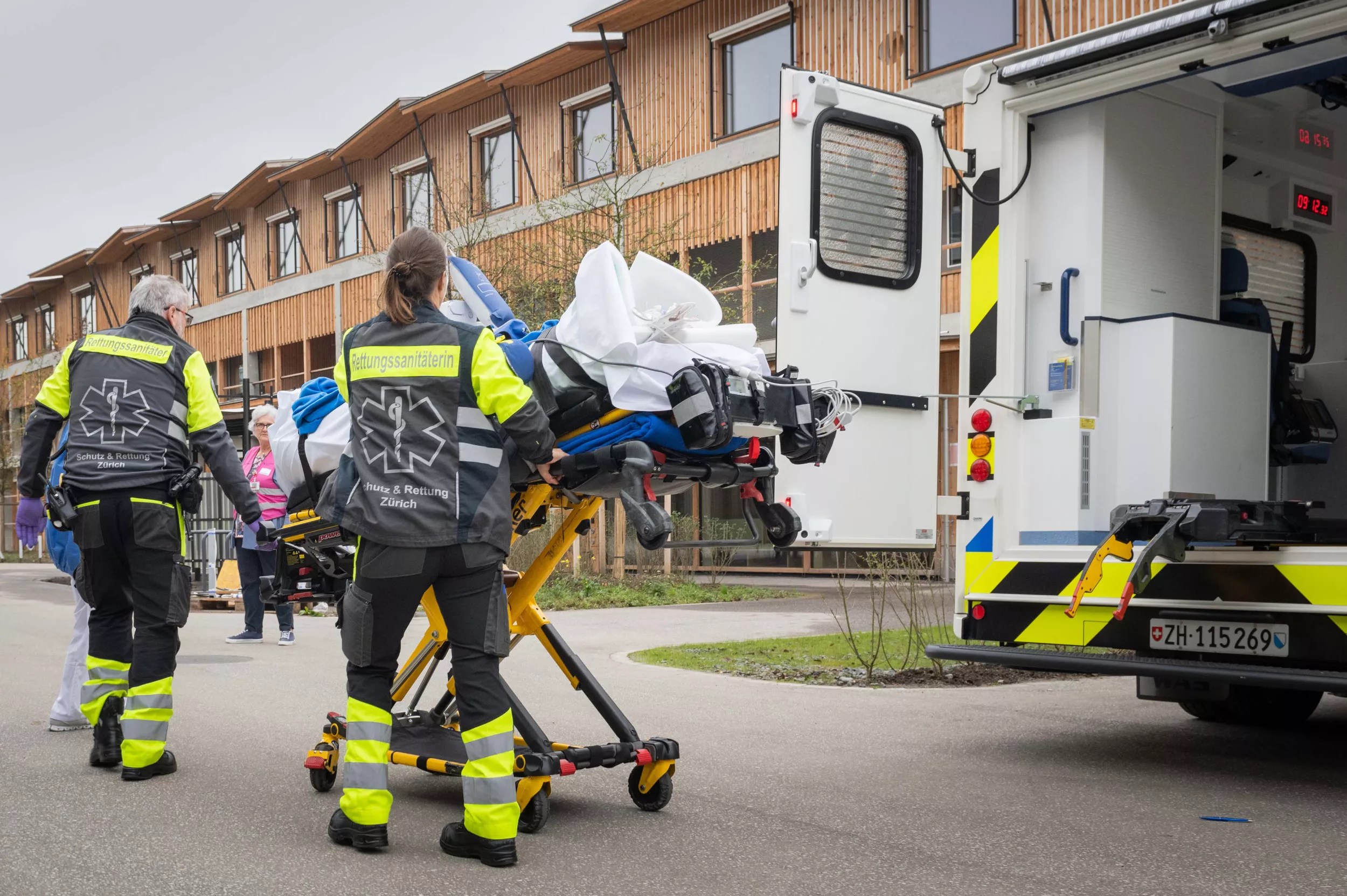 Rettungssanitäterinnen transportieren ein Kind auf einer Liege aus der Ambulanz ins Kinderspital