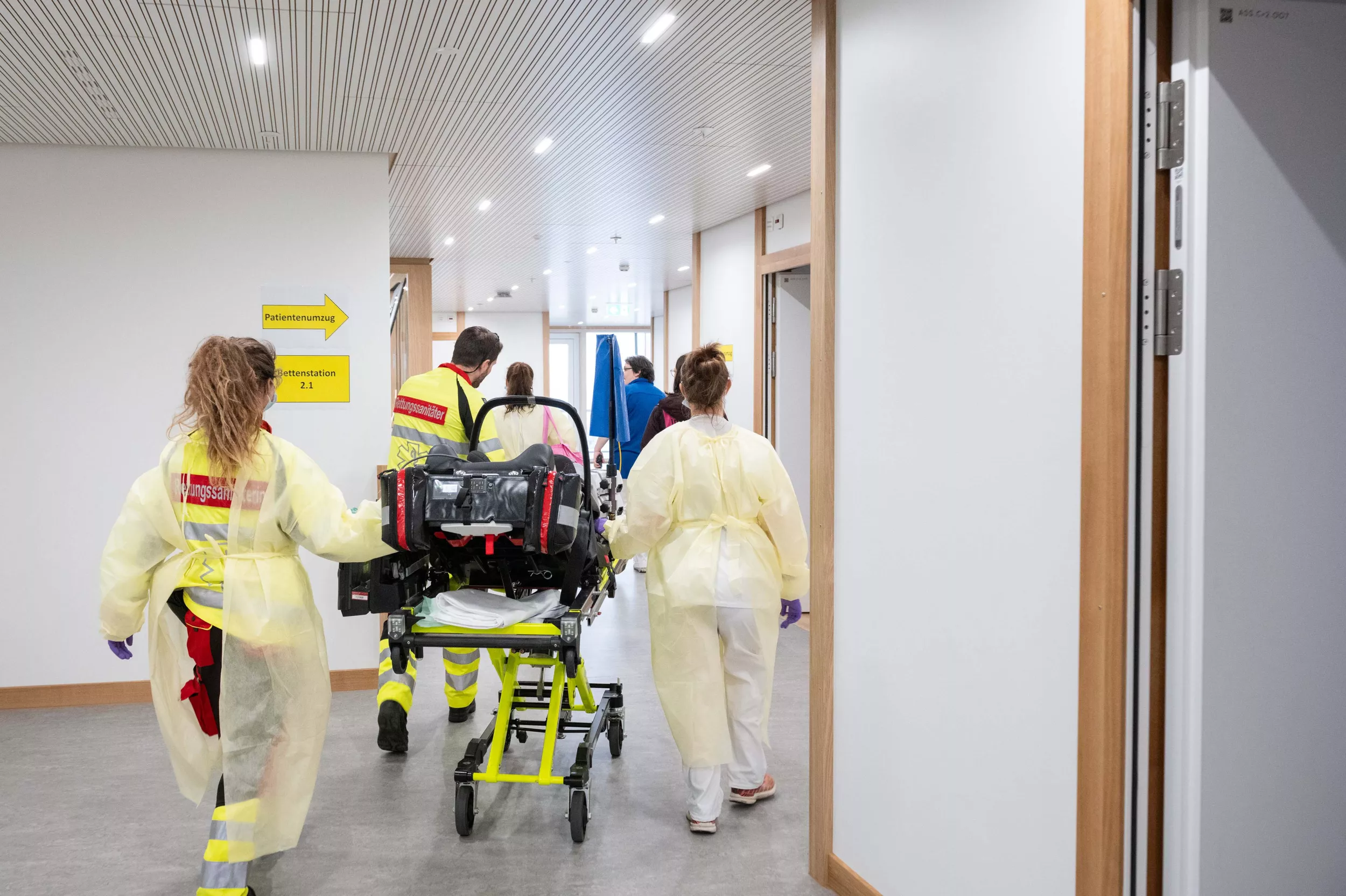 Rettungssanitäterinnen und medizinisches Personal transportieren ein Kind auf einer Liege im Kinderspital