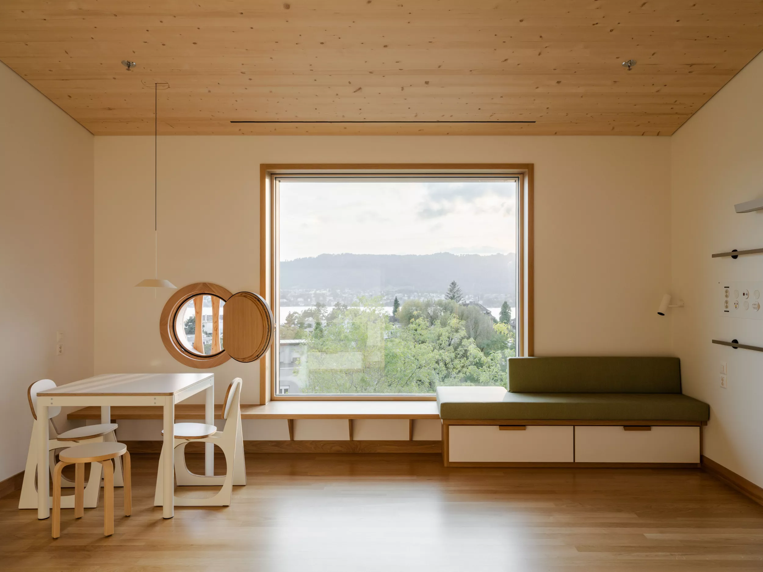 Patientenzimmer mit Sitzecke und Schlafsofa mit Seeblick im neuen Akutspital des Kinderspitals Zürich