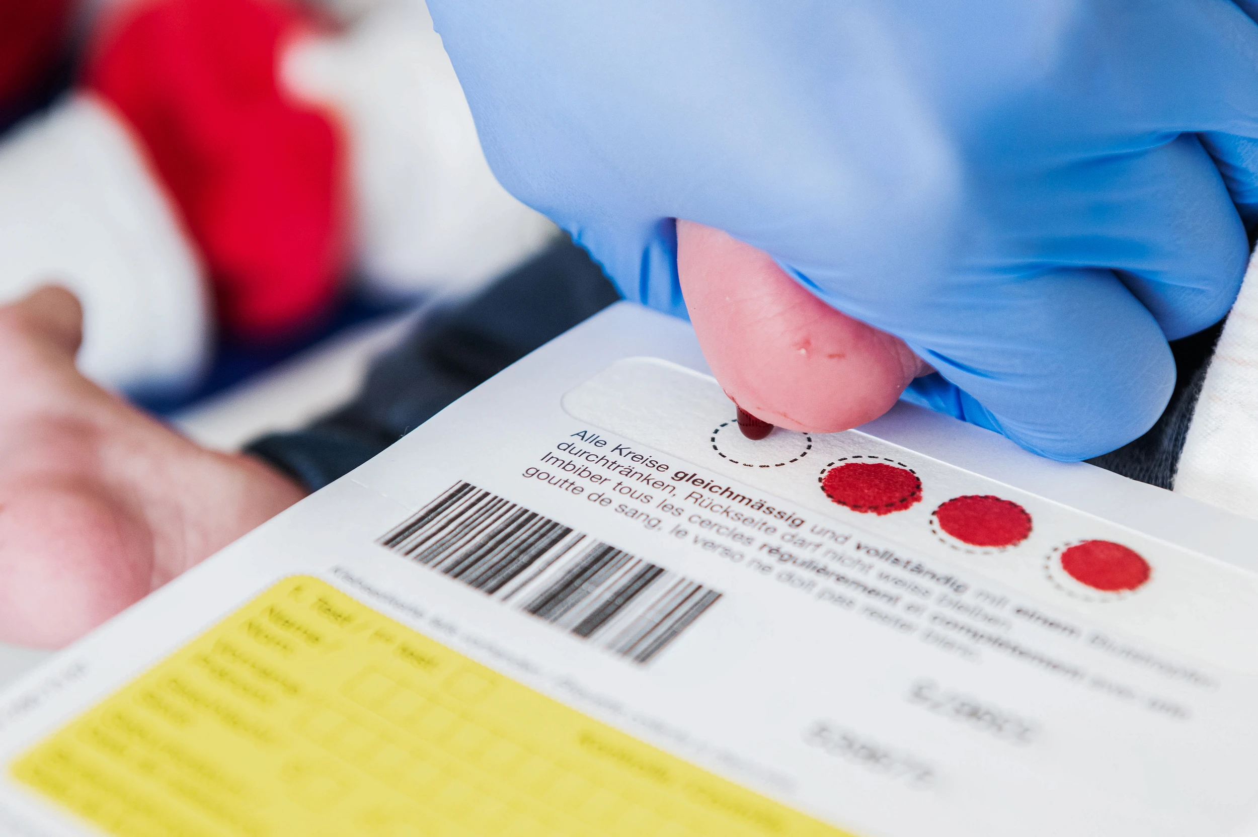 Am Fuss eines Neugeborenen wird Blut für das Neo-Screening auf eine Karte übertragen