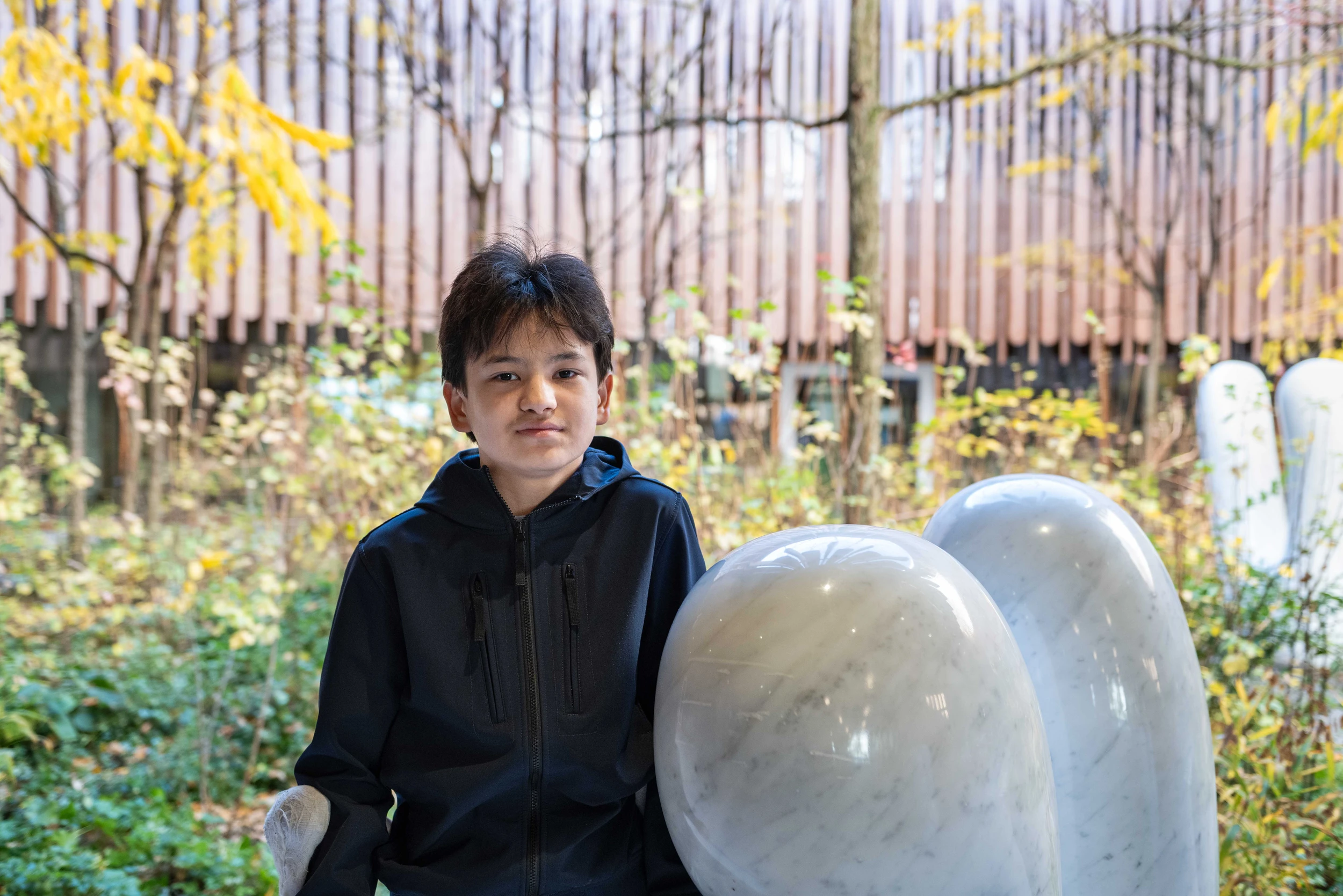 Ein Junge steht im Innenhof des Haupteingangs des Kinderspital Zürich
