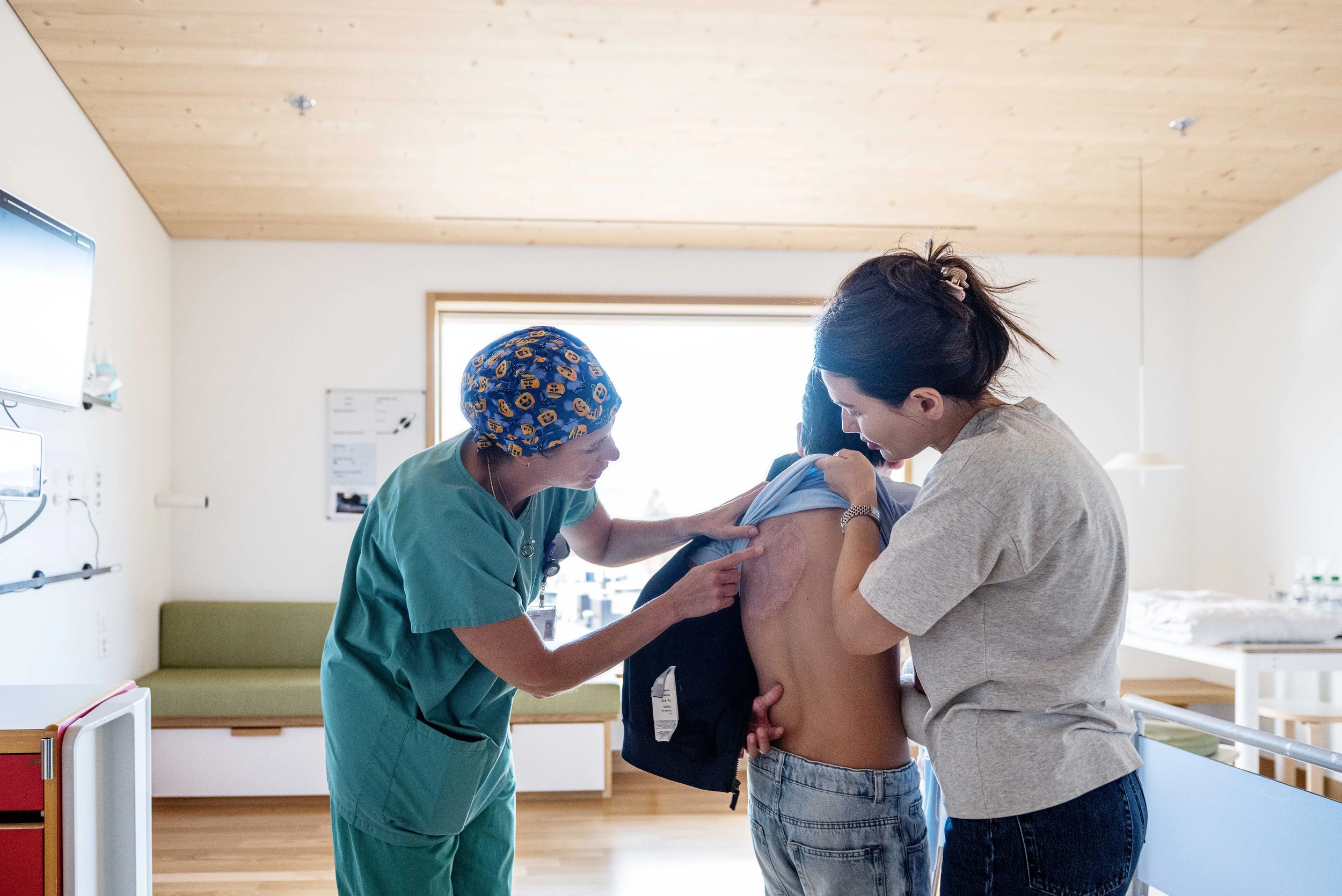 Eine Ärztin untersucht die Haut auf dem Rücken eines Patienten im Kinderspital Zürich