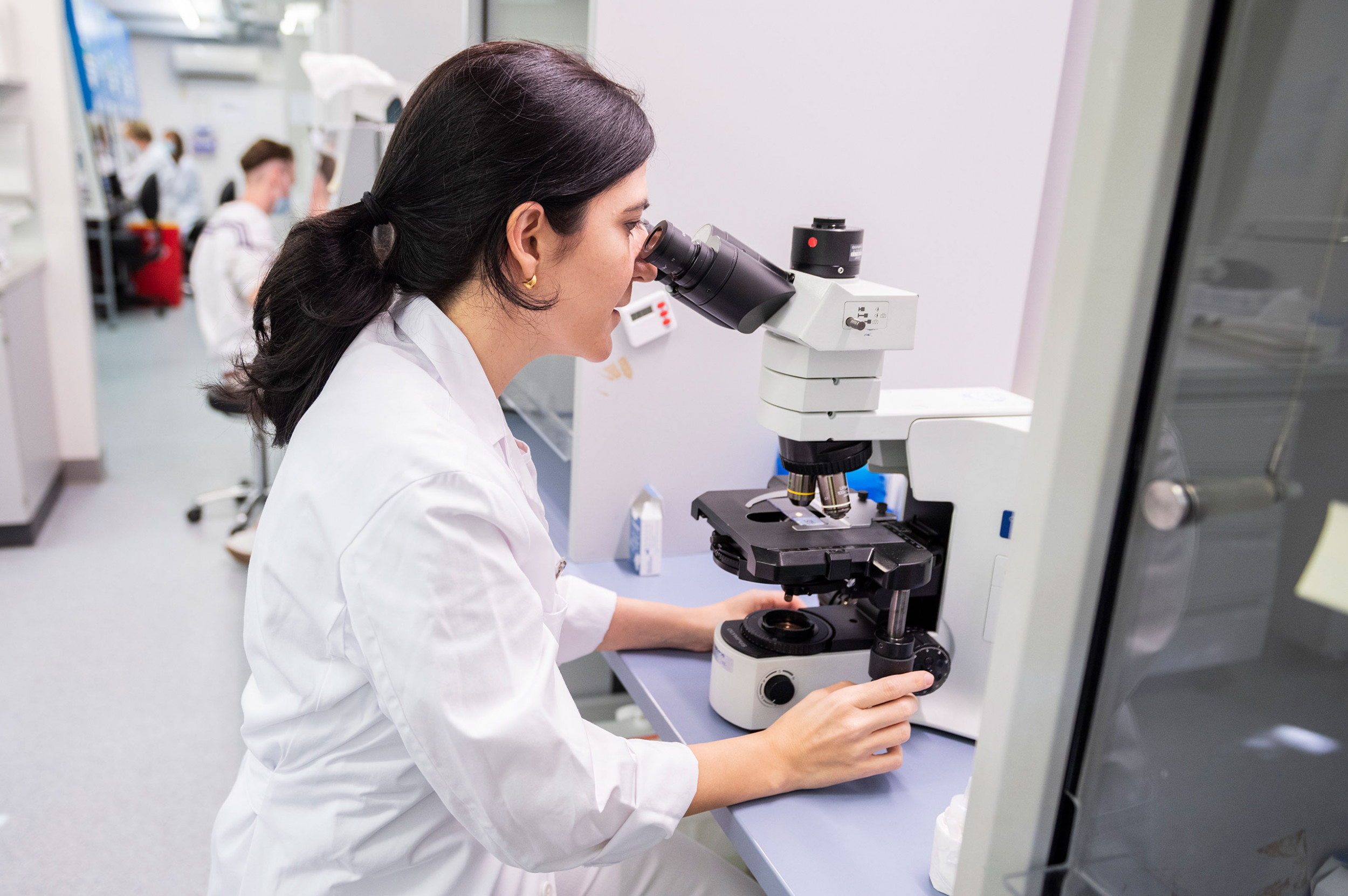 Ana Stücklin schaut im Onkologie Labor ins Mikroskop