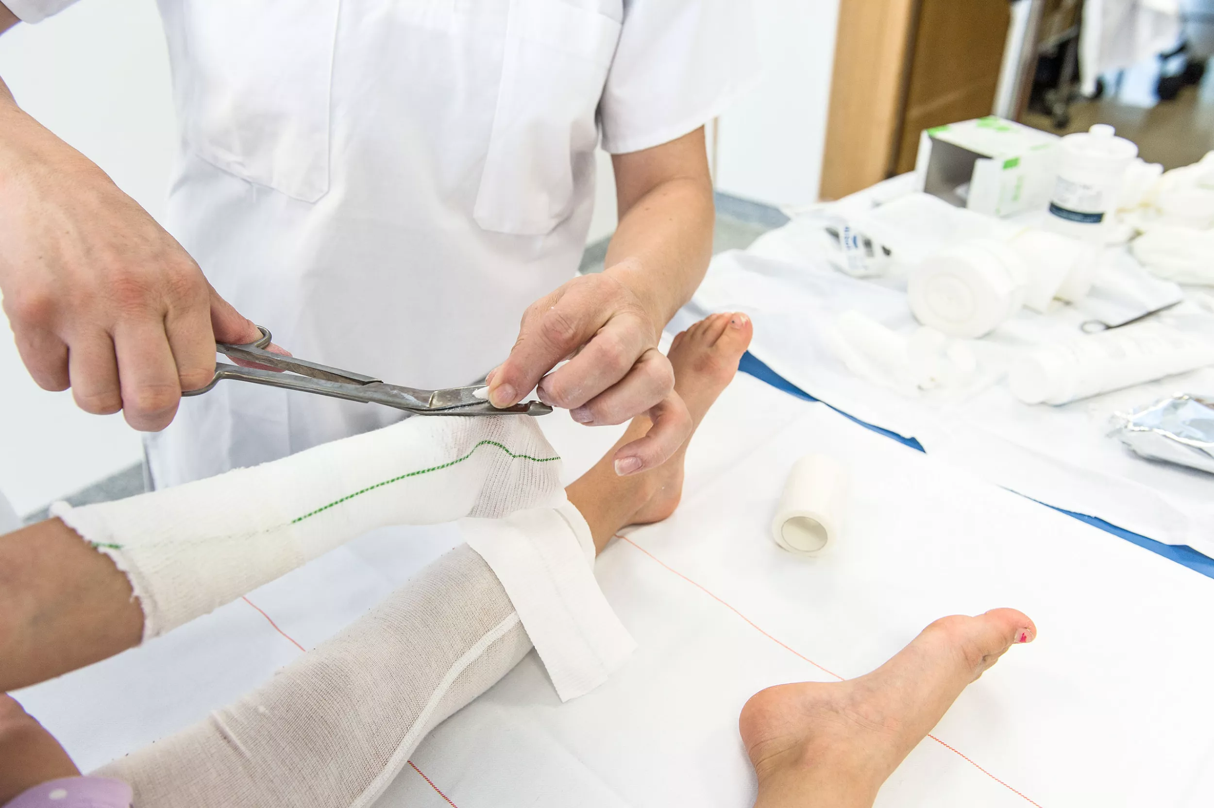 Wundberatung Dermatologie, Pflegende legt Mädchen einen Verband an