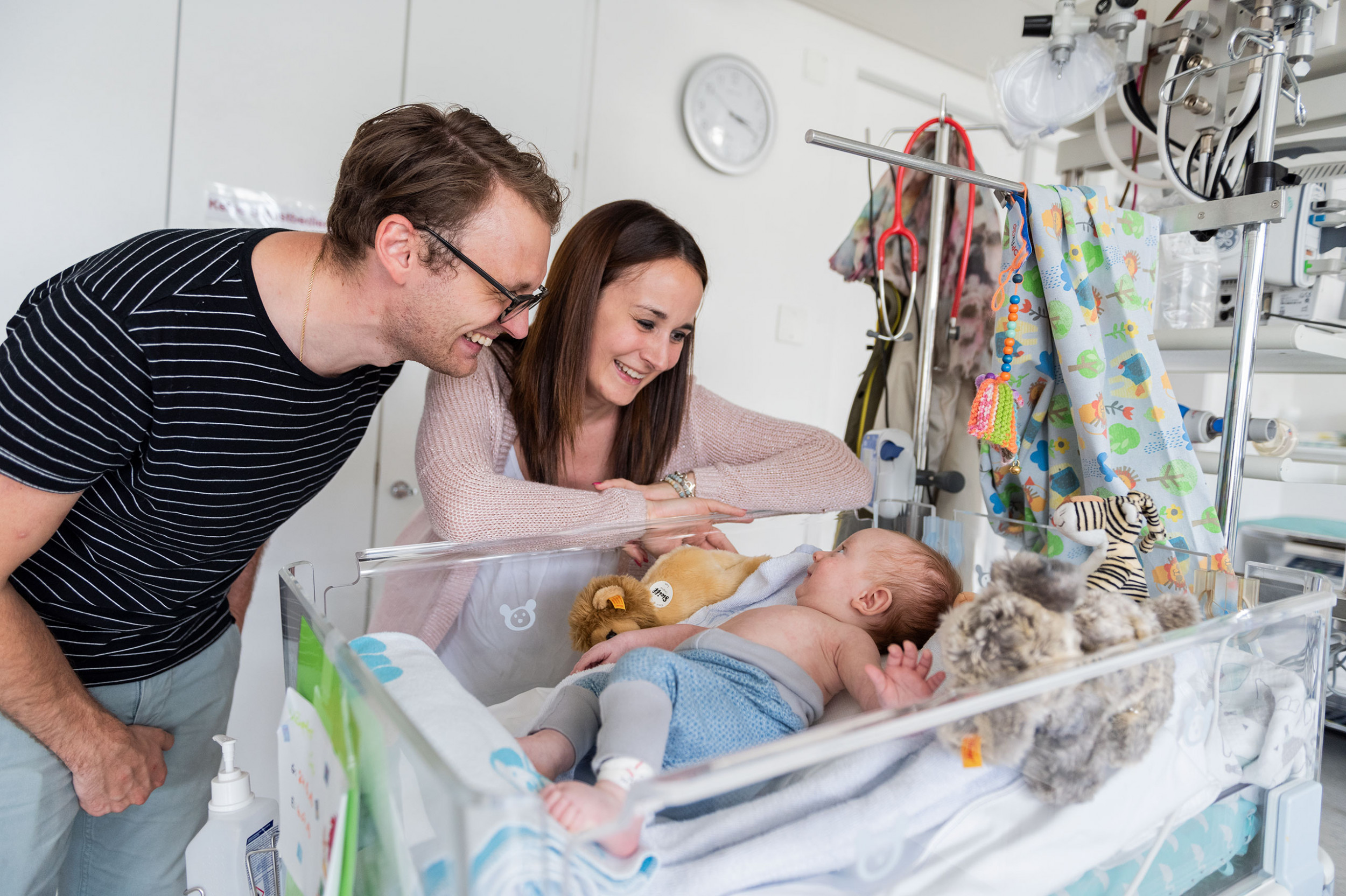 Junge Eltern lachen ihren Sohn an im Kinderspital Zürich