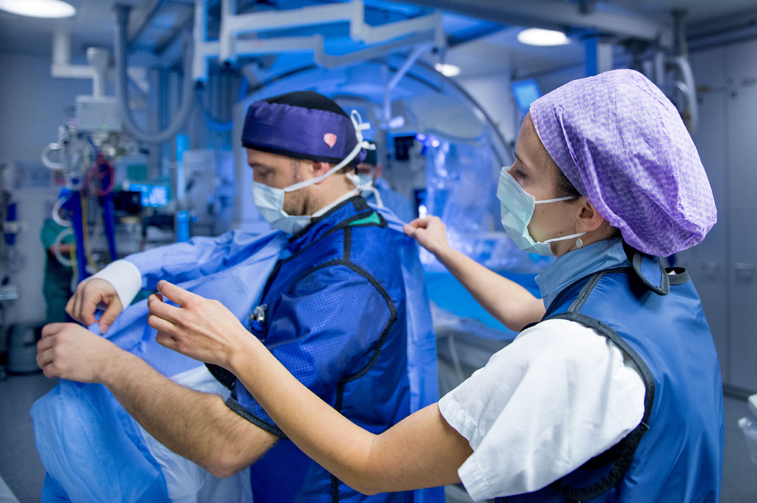 Eine Pflegefachfrau hilft dem Kardiochirurgen bei der Vorbereitung für einen Eingriff