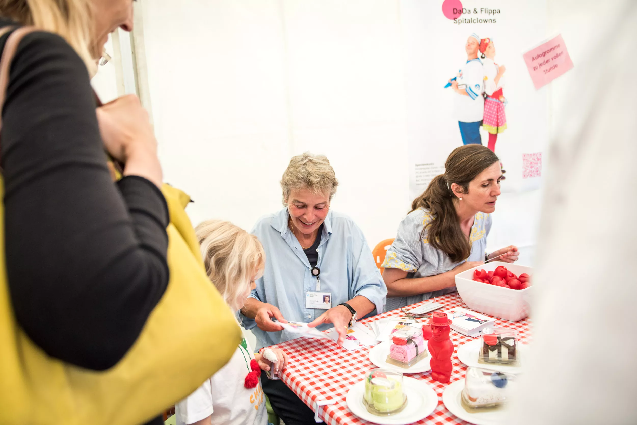 Frauen betreuen Stand der Spitalclowns 