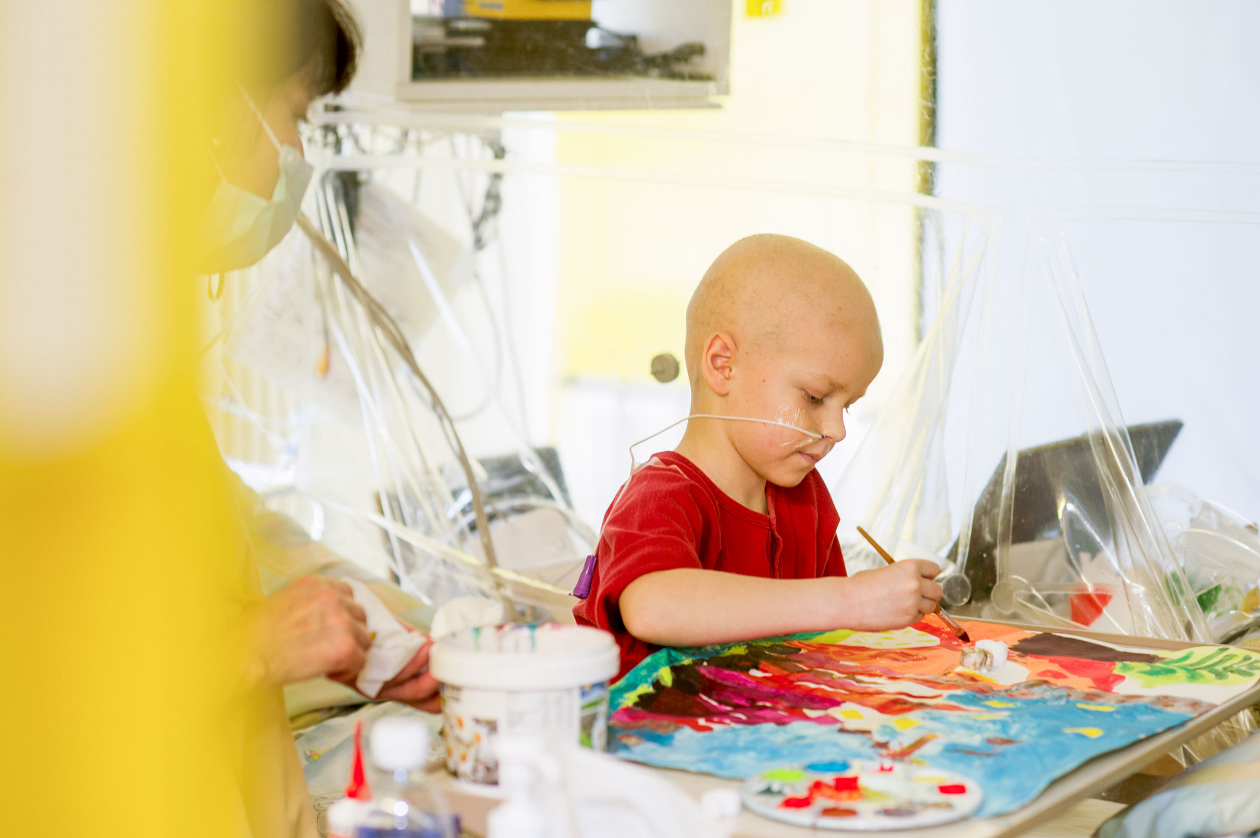 Ein krankes Kind malt ein Bild mit während der Kunsttherapie