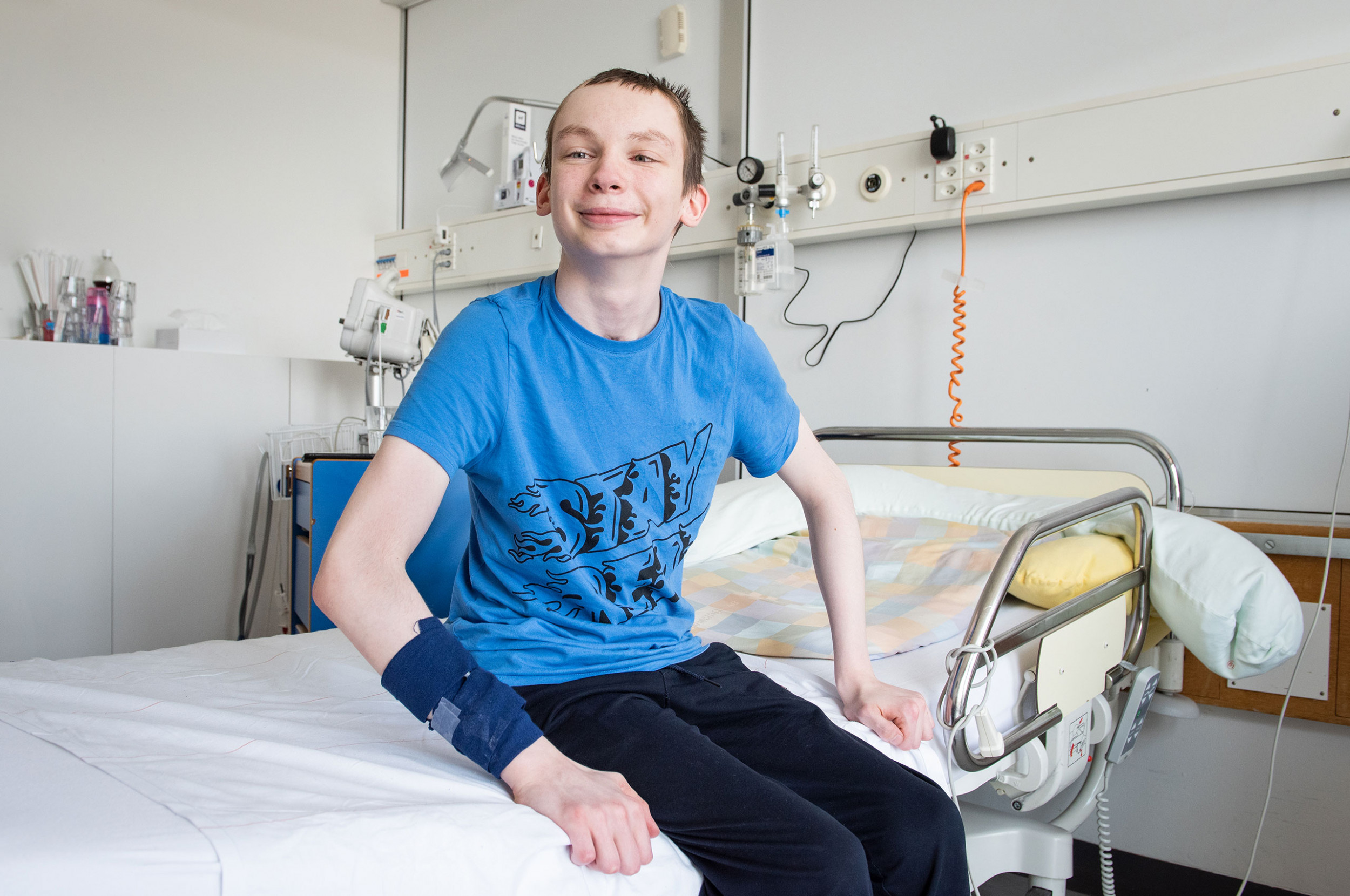 Ein Patient aus der Ukraine sitzt auf dem Bett im Spitalzimmer