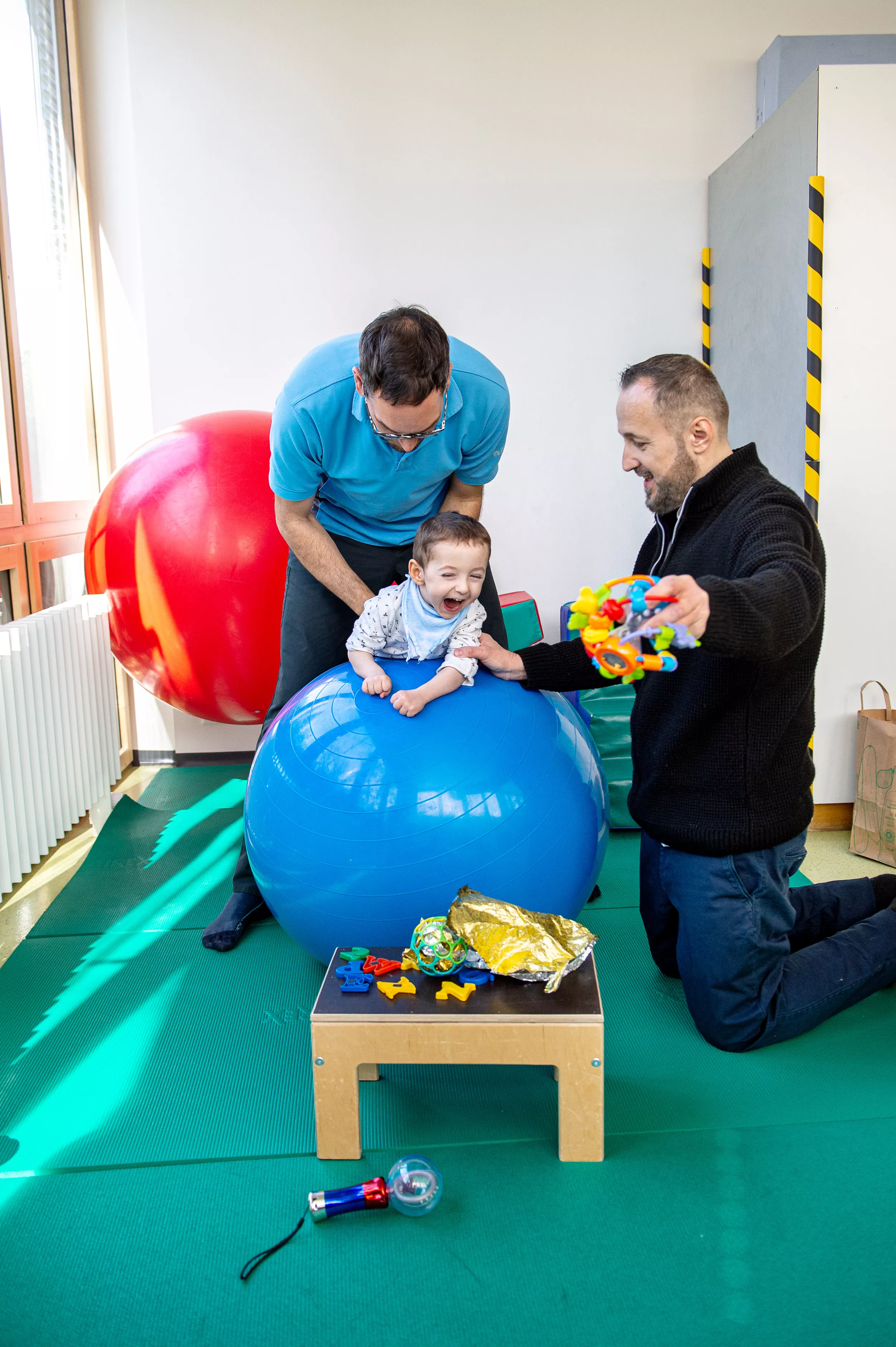 Kind auf Gymnastikball bei der Physiotherapie