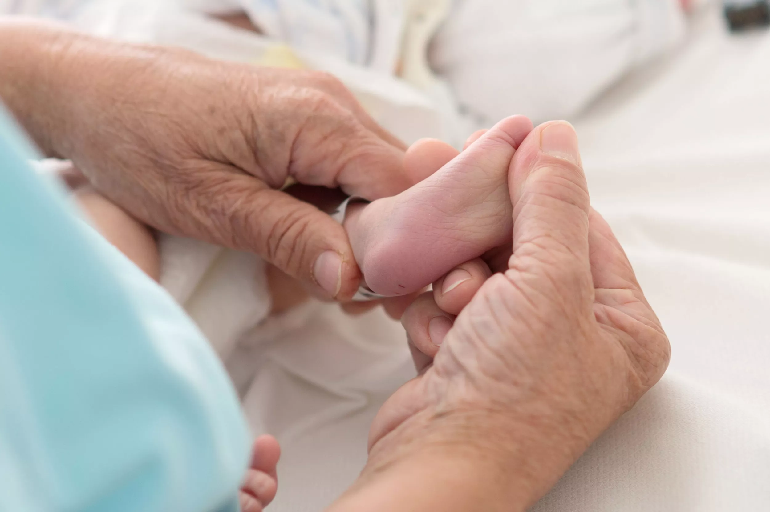 Physiotherapie, Therapeutin massiert sanft Fuss eines Patienten