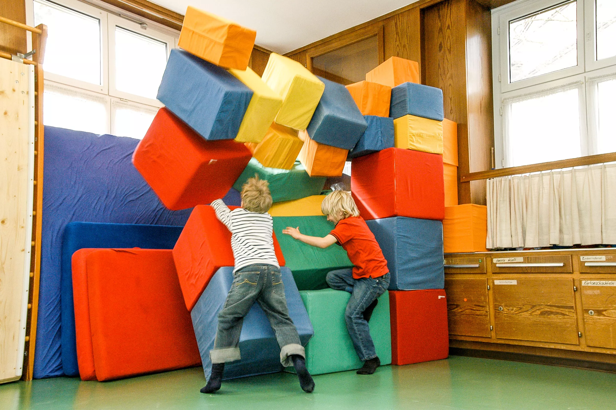 Psychomotorik, zwei Jungs spielen mit farbigen Stoffballen