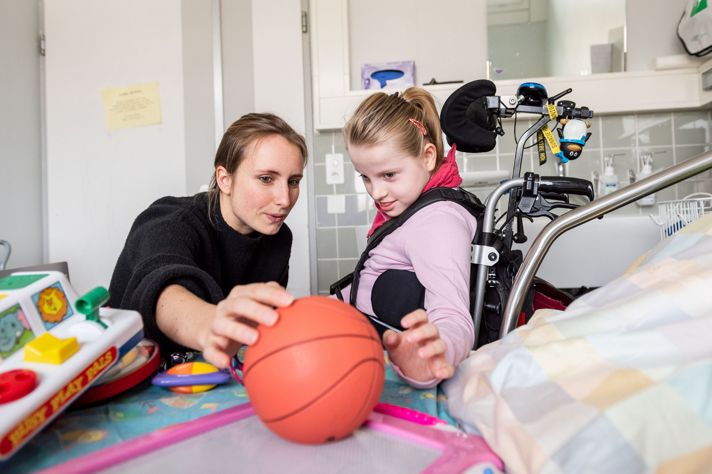 Eine Lehrerin der Spitalschule spielt mit einem behinderten Mädchen während des Unterrichts 