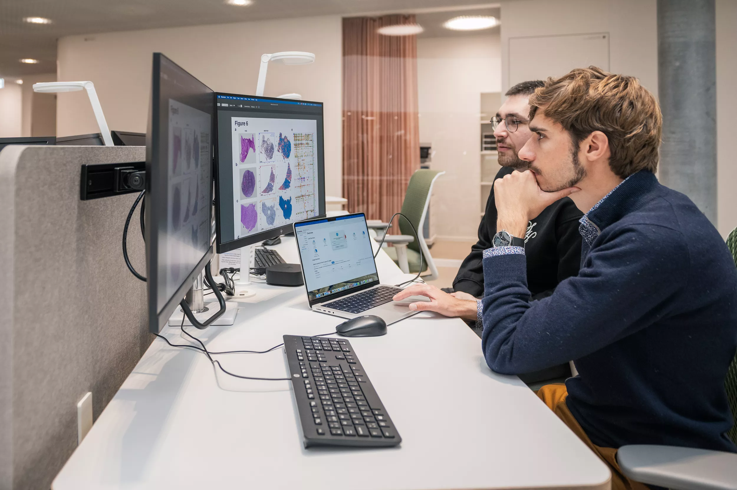 Zwei Forscher sitzen an einem Computer und schauen in den Bildschirm rein