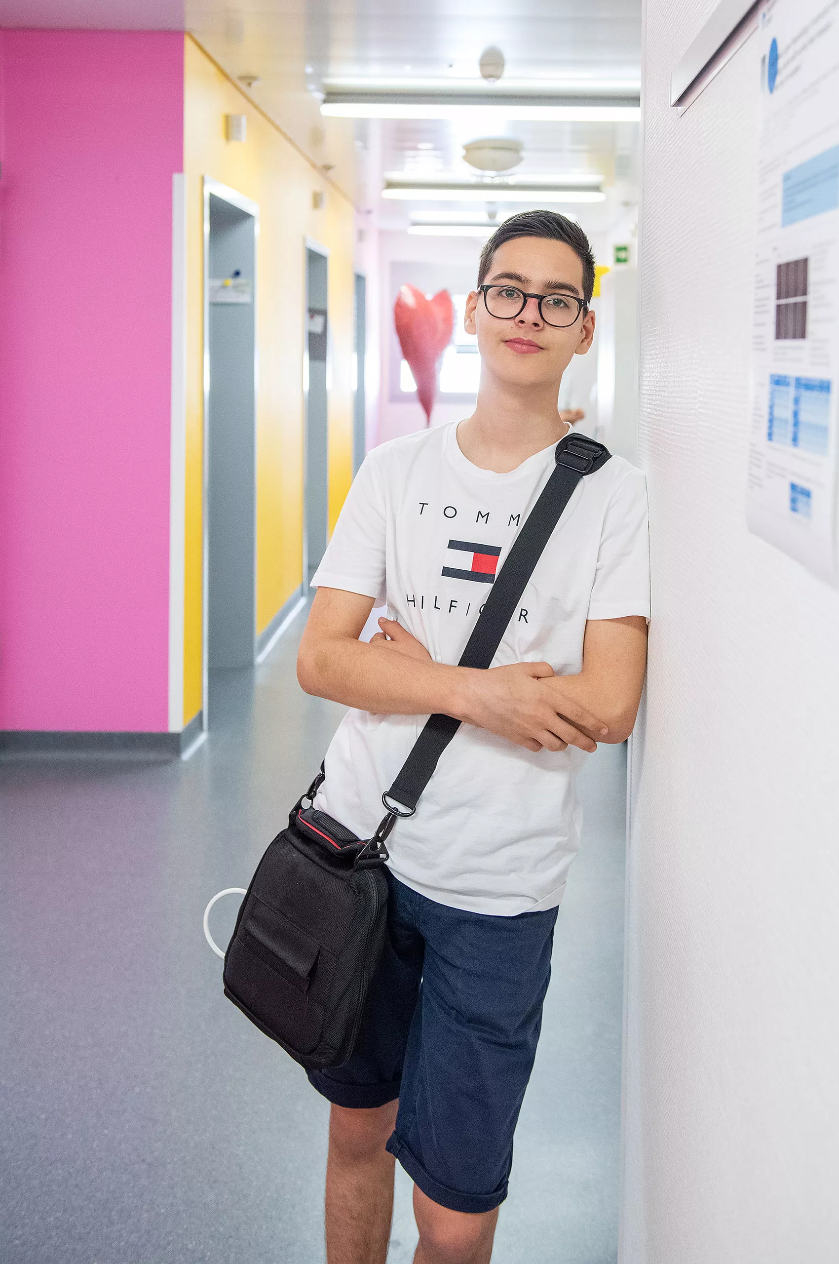Ein Junge steht in der kardiologischen Poliklinik und schaut in die Kamera