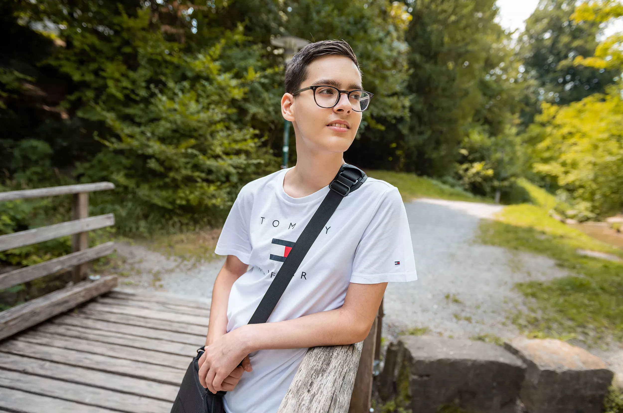 Ein Junge posiert vor der Kamera auf einem Waldweg