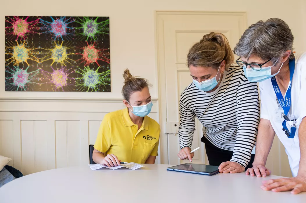 Drei Spital Mitarbeiterinnen fotografiert während einer Besprechung.