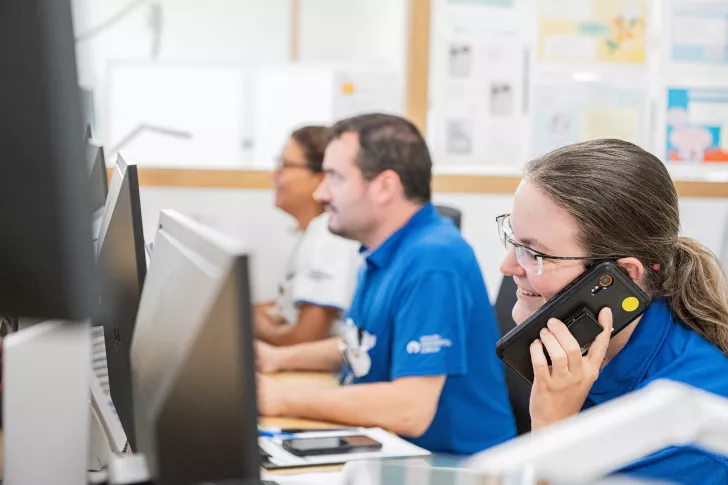 Pflegefachpersonen sitzen am Empfang und telefonieren