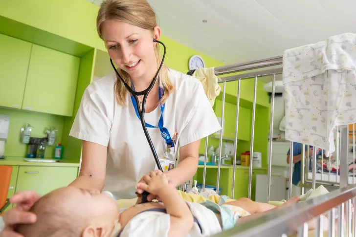 Assistenzärztin untersucht Säugling