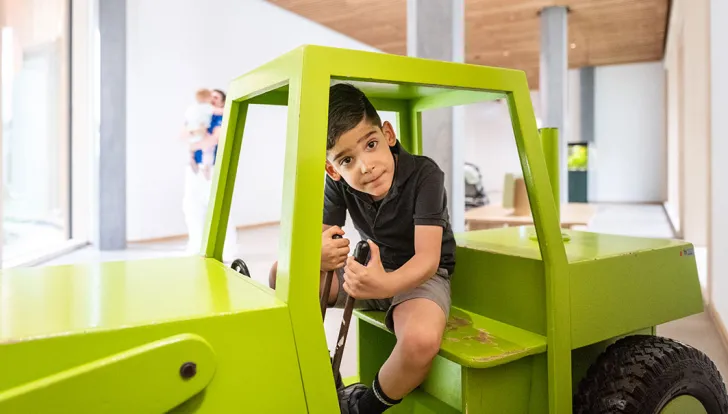 Spina Bifida Zentrum, Patient im grünen Traktor vor der Poliklinik