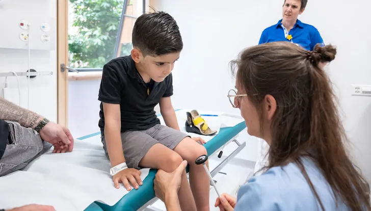 Spina Bifida Zentrum, Ärztin kontrolliert bei Patient Kniereflexe