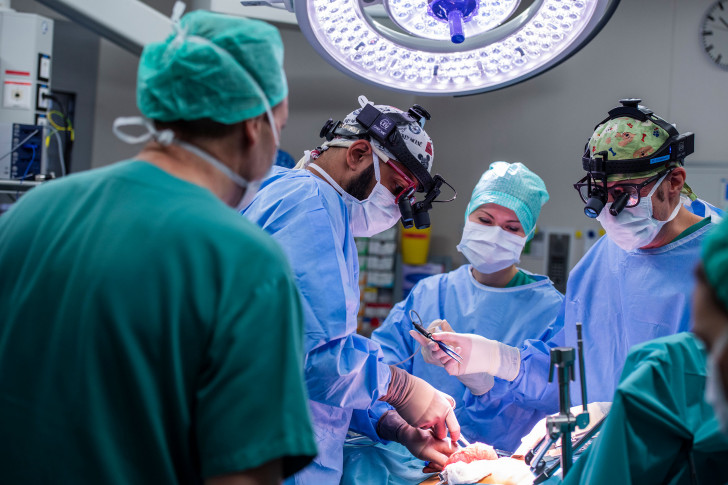 Die Chirurgen Ueli Möhrlen und Sasha Tharakan mit der Instrumentalistin während einer Operation